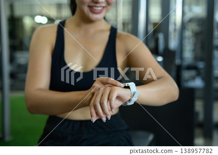 Closeup woman using smartwatch tracking data workout in gym 138957782