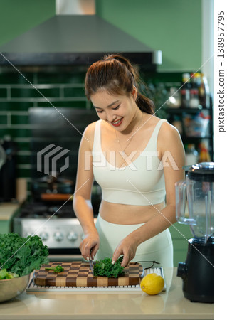 Woman chopping fresh kale on wooden cutting board 138957795