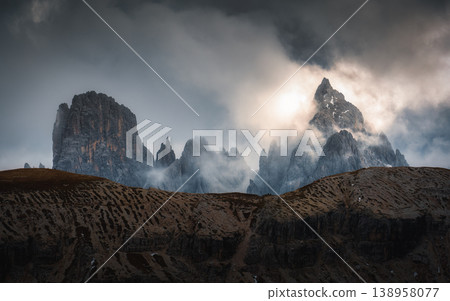 Moody rugged mountain peak with misty in Tre Cime, Dolomites Moody rugged mountain peak with misty in Tre Cime, Dolomites 138958077