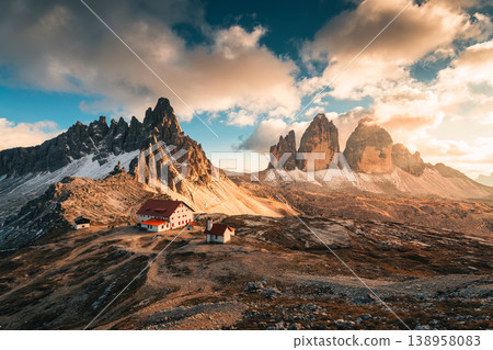 Scenic view of Tre Cime di Lavaredo peaks and mountain hut in the sunset at Dolomites, italy Scenic view of Tre Cime di Lavaredo peaks and mountain hut in the sunset at Dolomites, italy 138958083