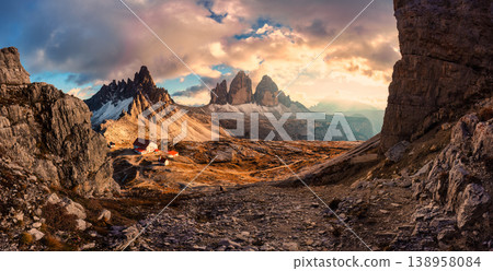 Golden hour panorama of Tre Cime di Lavaredo mountain peak with mountain hut during autumn in Dolomites, Italy Golden hour panorama of Tre Cime di Lavaredo mountain peak with mountain hut during autumn in Dolomites, Italy 138958084