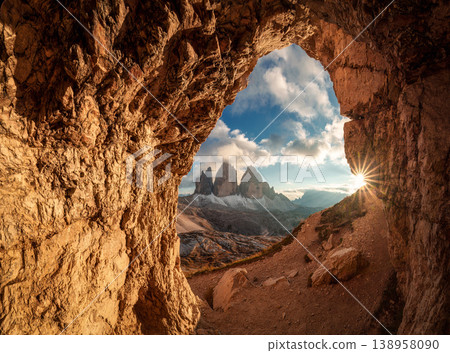 Rocky cave Grotta delle Tre Cime framing Tre Cime di Lavaredo mountain peaks during sunset in Dolomites, Italy 138958090