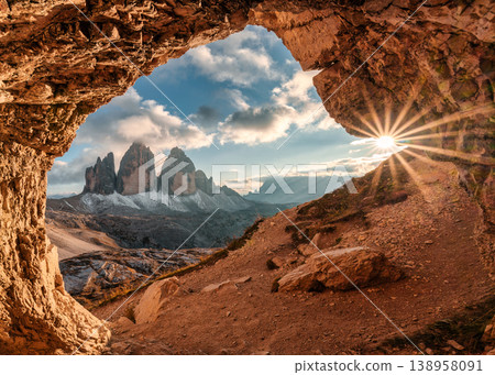 Grotta delle Tre Cime rocky tunnel framing sunset view of Tre Cime di Lavaredo mountain peak in Dolomites, Italy Grotta delle Tre Cime rocky tunnel framing sunset view of Tre Cime di Lavaredo mountain peak in Dolomites, Italy 138958091