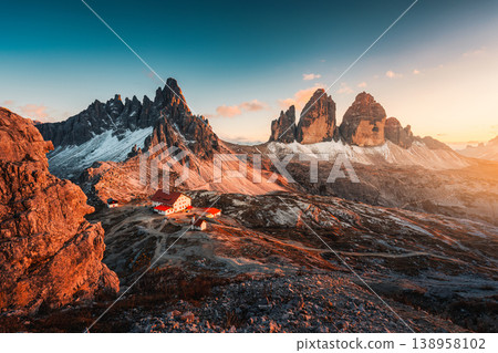 Alpine landscape of sunset over Tre Cime mountain peak and mountain hut during autumn in Dolomites, Italy Alpine landscape of sunset over Tre Cime mountain peak and mountain hut during autumn in Dolomites, Italy 138958102