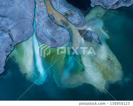 Above of abstract frozen lake shore with turquoise water and frost covered land 138958123