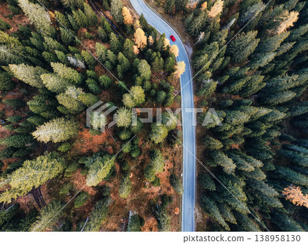 Autumn alpine landscape with car driving on snake road surrounded by pine forest Autumn alpine landscape with car driving on snake road surrounded by pine forest 138958130
