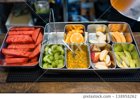 Fresh sliced fruits in stainless steel tray at juice bar counter 138958262