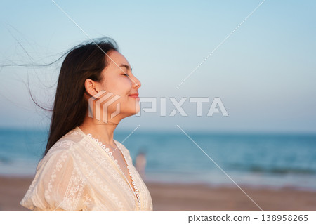 Peaceful attractive woman breathing fresh air on sea beach Peaceful attractive woman breathing fresh air on sea beach 138958265