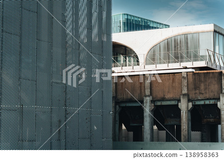 Metallic perforated mesh texture wall with arched glass windows, aged concrete structure building Metallic perforated mesh texture wall with arched glass windows, aged concrete structure building 138958363