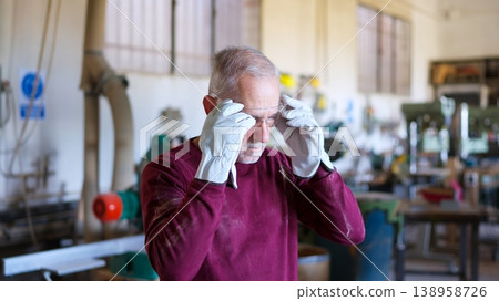 Senior craftsman adjusting safety goggles in workshop Senior craftsman adjusting safety goggles in workshop 138958726
