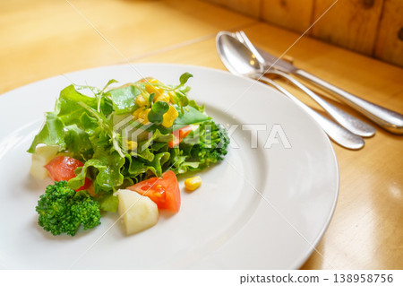 一份包含新鮮蔬菜的沙拉和精緻的開胃菜。 一份包含新鮮蔬菜的沙拉和精緻的開胃菜。 138958756