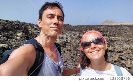 Couple smiling, hiking lava fields on a sunny day Couple smiling, hiking lava fields on a sunny day 138958796