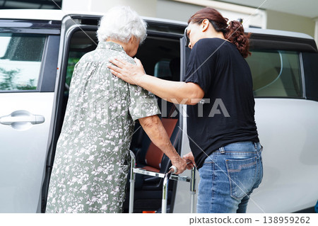 Caregiver help Asian elderly woman disability patient get in her car. Caregiver help Asian elderly woman disability patient get in her car. 138959262