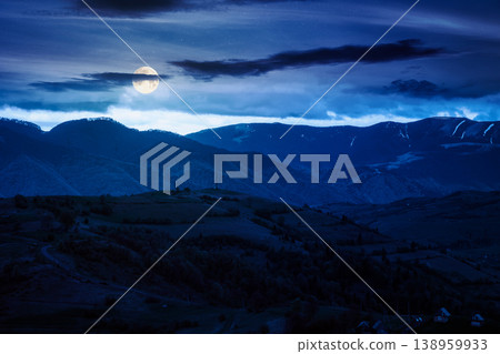 mountainous countryside scenery at night. full moon over dark sky view above the valley. green fields and trees on the hills. mysterious nature scenery of carpathian mountains mountainous countryside scenery at night. full moon over dark sky view above the valley. green fields and trees on the hills. mysterious nature scenery of carpathian mountains 138959933