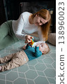 Happy mother playing with her infant baby boy on the floor at home 138960023