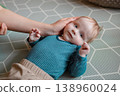 Loving mother's hands gently cradling her baby boy's head 138960024