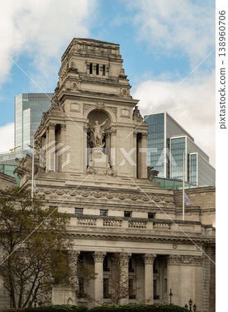 The stately Portland stone of Ten Trinity Square commands the scene, its intricate carvings and Corinthian columns embodying Beaux-Arts grandeur. Atop the great tower, a colossal statue of Old Father The stately Portland stone of Ten Trinity Square commands the scene, its intricate carvings and Corinthian columns embodying Beaux-Arts grandeur. Atop the great tower, a colossal statue of Old Father 138960706