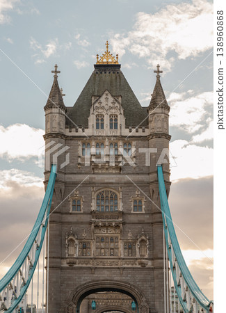 Rising as majestic Victorian Gothic sentinels, the towers of Tower Bridge welcome travelers into the heart of London through their glowing portals. Their thick blue cables and heavy stone masonry 138960868