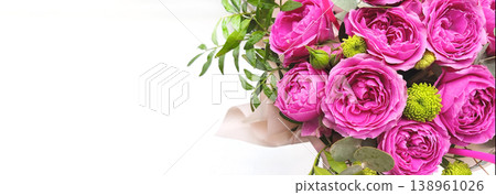 Close-up bouquet of pink peony roses with green leaves in elegant packaging. Botanical background with copy space for message and congratulations. A floral gift for a special occasion. Close-up bouquet of pink peony roses with green leaves in elegant packaging. Botanical background with copy space for message and congratulations. A floral gift for a special occasion. 138961026