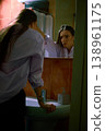 Woman looking at herself in mirror with tense expression in the bathroom. 138961175