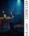 Business woman working late at desk with laptop in dark smoky office lighting. 138961184