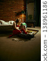 Woman sitting by open suitcase with phone in hand in moody loft bedroom interior. 138961186