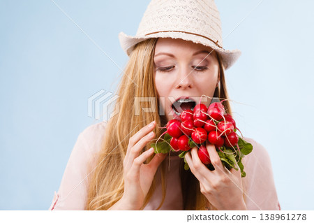 Happy woman biting radish Happy woman biting radish 138961278