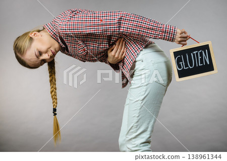 Woman feeling stomach cramps holding gluten board Woman feeling stomach cramps holding gluten board 138961344