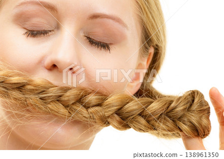 Blonde girl covering her mouth with braid hair 138961350