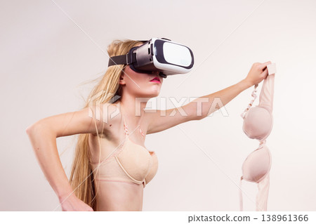 Girl in virtual reality goggles holds bra 138961366