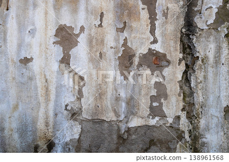 Weathered concrete wall with peeling plaster and water damage 138961568