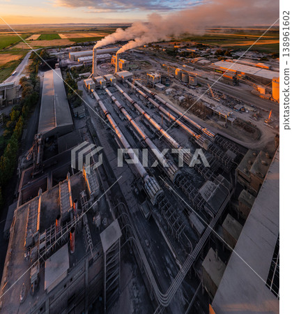 aerial wide angle Industrial cement plant with smokestacks and agricultural fields at sunset aerial wide angle Industrial cement plant with smokestacks and agricultural fields at sunset 138961602