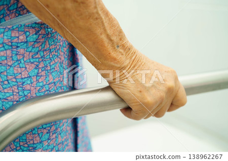 Asian elderly woman patient use toilet support rail in bathroom. Asian elderly woman patient use toilet support rail in bathroom. 138962267