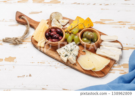 Cheese board with assorted cheeses and olives Cheese board with assorted cheeses and olives 138962809