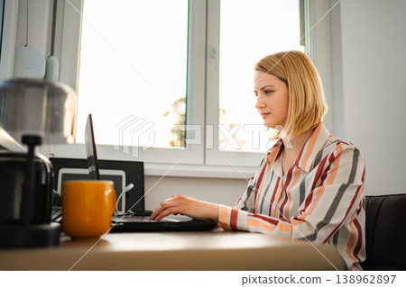 Young woman working remotely at home using laptop Young woman working remotely at home using laptop 138962897