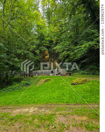 Peaceful walking path with stone steps winding through a lush green forest. Peaceful walking path with stone steps winding through a lush green forest. 138962974