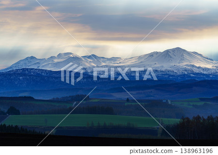 A view of the hills and the Daisetsuzan Mountains from Miyama Pass in Kamifurano, Hokkaido. A view of the hills and the Daisetsuzan Mountains from Miyama Pass in Kamifurano, Hokkaido. 138963196