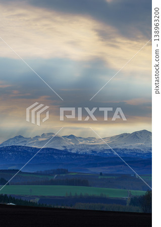 A view of the hills and the Daisetsuzan Mountains from Miyama Pass in Kamifurano, Hokkaido. 138963200