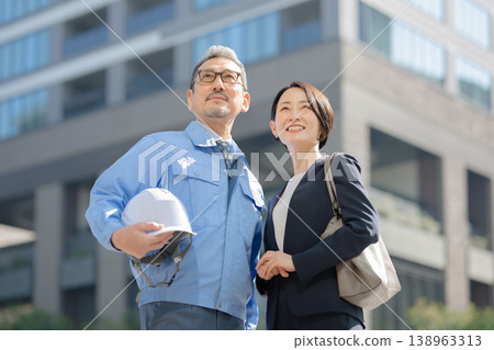 A man in work clothes and a woman in a suit A man in work clothes and a woman in a suit 138963313