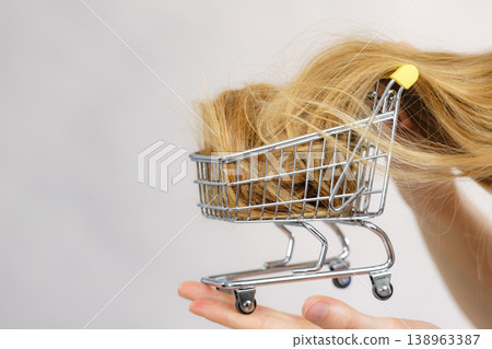 Girl with her long hair in shopping cart Girl with her long hair in shopping cart 138963387