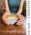 Woman hand holding coffee cup latte art female hand holding coffee cup latte art wooden table cafe relaxing morning casual 138963594
