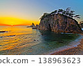 A view of the sunset sinking below the horizon of the Sea of Japan against a clear, bright sunset sky, and the Megane-iwa rock formation in Sasagawa-nagare. Ver4 138963623