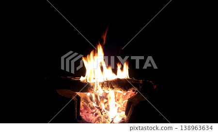 The hot embers of burning wood log fire isolated on black. Firewood burning on stove. 138963634