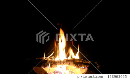 The hot embers of burning wood log fire isolated on black. Firewood burning on stove. 138963635