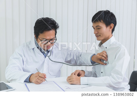 Doctor Checking Patient With Stethoscope. Doctor listening to patient chest with stethoscope in his office at the hospital. Doctor Checking Patient With Stethoscope. Doctor listening to patient chest with stethoscope in his office at the hospital. 138963802