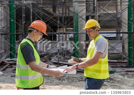 Confident team of architect working together in building construction site. They discussing about new startup project. Architect discuss with engineer about project . Architectural concept. Confident team of architect working together in building construction site. They discussing about new startup project. Architect discuss with engineer about project . Architectural concept. 138963803
