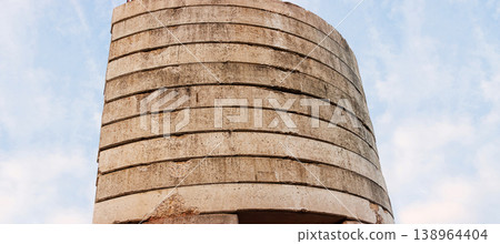 Minimalist low angle view of concrete blocks making the tower crane counterweight against a bright cloudy sky with copy space. 138964404