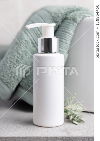 White pump cosmetic bottle mockup near leaves and sage green towel in bathroom. Unbranded packaging 138964450