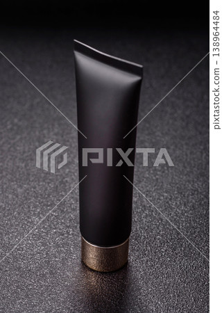 Black empty plastic tube for cream, paste, or shampoo as a mockup. An empty cosmetic tube mockup Black empty plastic tube for cream, paste, or shampoo as a mockup. An empty cosmetic tube mockup 138964484