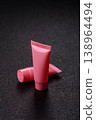 Pink empty plastic tube for cream, paste or shampoo as a mockup. Empty cosmetic tube mockup 138964494